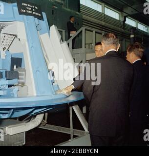 Inspection tour of NASA installations: Houston, Texas, NASA Rich Building, departure, 11:10AM. President John F. Kennedy and Vice President Lyndon B. Johnson (both with backs to camera) view a mock-up of the interior of a Gemini capsule, during a tour of spacecraft displays inside a hangar at the Rich Building of the Manned Spacecraft Center, Houston, Texas; astronaut Major Virgil I. u201cGusu201d Grissom briefs President Kennedy and Vice President Johnson. The President visited the Center as part of a two-day inspection tour of National Aeronautics and Space Administration (NASA) field inst Stock Photo