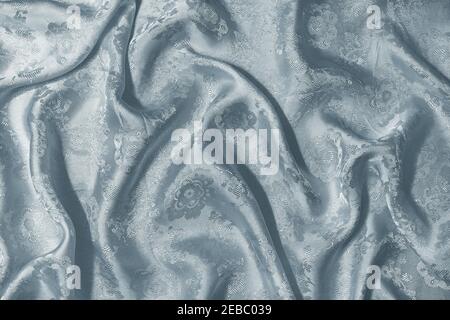 Background with the texture of green silk fabric draped with pleats. Stock Photo