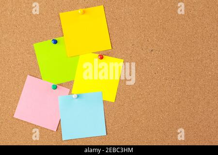 Cork board with several colorful blank notes with pins Stock Photo