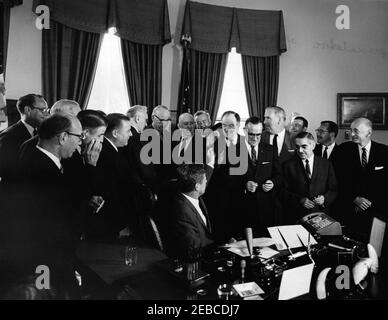 Bill signing, H.R. 11040 Public Law 87-624, Communications Satellite Act of 1962, 9:45AM. President John F. Kennedy hands a pen to Senator John Sparkman of Alabama during a signing ceremony for HR 11040, the Communications Satellite Act of 1962. (L-R) Representative John B. Bennett of Michigan; Representative Samuel N. Friedel of Maryland (front, wearing glasses); Representative J. Arthur Younger of California (mostly hidden behind Representative Friedel); Representative Oren Harris of Arkansas (hand partially covering face); Senator Warren G. Magnuson of Washington; Speaker of the House of Re Stock Photo