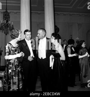 Dinner in honor of Vice President Lyndon B. Johnson (LBJ), Speaker of the House John W. McCormack, u0026 Chief Justice Earl Warren, 8:00PM. Vice President Lyndon B. Johnson (third from left) and Lady Bird Johnson visit with unidentified guests at a dinner in honor of Vice President Johnson, Speaker of the House of Representatives John W. McCormack, and Supreme Court Chief Justice Earl Warren. Standing in the background at right are (L-R): Chairman of the Atomic Energy Commission Glenn T. Seaborg; Beryl Hastie, wife of Judge William H. Hastie (facing away); Judge Hastie (mostly hidden); and Dr Stock Photo