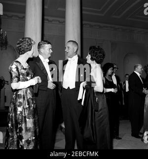 Dinner in honor of Vice President Lyndon B. Johnson (LBJ), Speaker of the House John W. McCormack, u0026 Chief Justice Earl Warren, 8:00PM. Vice President Lyndon B. Johnson (third from left) and Lady Bird Johnson visit with unidentified guests at a dinner in honor of Vice President Johnson, Speaker of the House of Representatives John W. McCormack, and Supreme Court Chief Justice Earl Warren. Standing in the background at right are (L-R): Beryl Hastie, wife of Judge William H. Hastie; Judge Hastie; Administrator of the Housing and Home Finance Agency Robert C. Weaver; and Dr. Ella Haith Weave Stock Photo