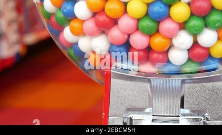 Colorful gumballs in classic vending machine, USA. Multi colored buble gums, coin operated retro dispenser. Chewing gum candies as symbol of childhood Stock Photo