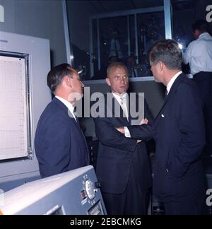 Presentation of the NASA (National Aeronautics and Space Administration) Distinguished Service Medal (DSM) to Astronaut John Herschel Glenn, Jr., at Cape Canaveral. Project Mercury Flight Director Christopher C. Kraft, Jr. (left) and astronaut Lieutenant Colonel John H. Glenn, Jr. (center) brief President John F. Kennedy on the operation of the Mercury Control Center at Cape Canaveral Air Force Station, prior to the presentation ceremony of the National Aeronautics and Space Administration (NASA) Distinguished Service Medal to Lieutenant Colonel Glenn. Brevard County, Florida. Stock Photo