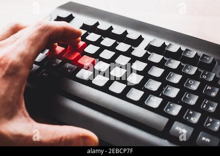 Male hand on the keyboard - game keys distract from work with thoughts about a computer game Stock Photo