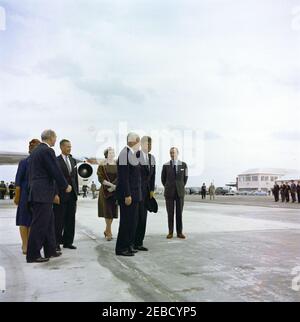 Trip to Bermuda: arrival at Kindley Air Force Base, Bermuda, 12:55PM. President John F. Kennedy visits with Prime Minister of Great Britain, Harold Macmillan, upon the Presidentu2019s arrival in Bermuda from Palm Beach, Florida. L-R: Lady Joyce Gascoigne (wife of Governor of Bermuda, Major General Sir Julian Gascoigne), partially hidden; US Secretary of State Dean Rusk; two unidentified; Prime Minister Macmillan; President Kennedy; British Ambassador to the United States Sir David Ormsby-Gore. Kindley Air Force Base, St. Davidu2019s Island, Bermuda. [Discoloration is original to the negative Stock Photo