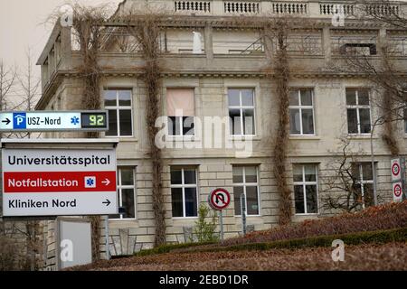 Signpost of Emergency room or E.R. direction at University Hospital Zurich in Switzerland and adjacent parking lot. Directions are in German. Stock Photo