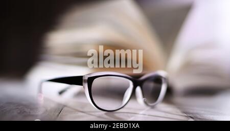 Composition with glasses and open book on the table. Stock Photo