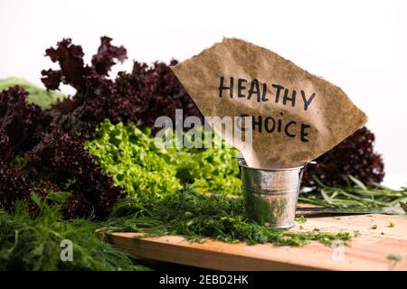 Healthy nutrition food concept greens and herbs backdrop cutting board dill and salad with parsley on the white background Stock Photo