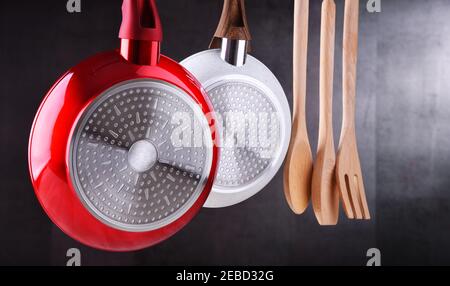 Two hanging frying pans and kitchen utensils Stock Photo