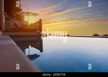 Exotic romantic sunset beatiful pool villa resort. Infinity pool with amazing sunset sky. Pool villa with beatiful pomantic view. Stock Photo