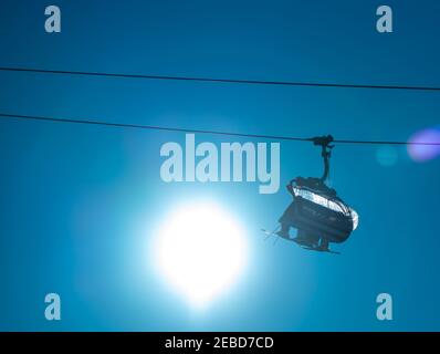 Family riding a ski lift to the top of a mountain at a ski resort. Stock Photo
