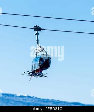 Family riding a ski lift to the top of a mountain at a ski resort. Stock Photo
