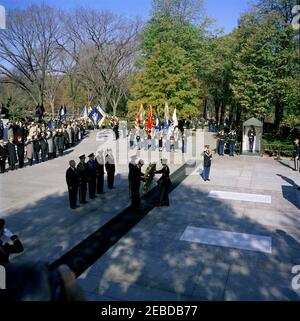 Address at Veterans Day Ceremonies, Arlington National Cemetery, 11:01AM. President John F. Kennedy participates in a wreath laying ceremony at the Tomb of the Unknown Soldier as part of Veterans Day remembrances. President Kennedy stands with Major General Paul A. Gavan, Commanding General of the Military District of Washington. Standing behind the President (L-R): John S. Gleason, Administrator of Veterans Affairs; Military Aide to the President General Chester V. Clifton; Air Force Aide to the President Colonel Godfrey T. McHugh; Naval Aide to the President Captain Tazewell T. Shepard; and Stock Photo