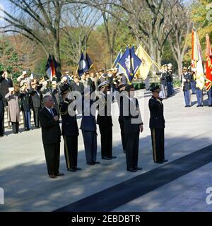 Address at Veterans Day Ceremonies, Arlington National Cemetery, 11:01AM. President John F. Kennedy participates in Veterans Day ceremonies. President Kennedy stands with Major General Paul A. Gavan, Commanding General of the Military District of Washington. Standing behind the President (L-R): John S. Gleason, Administrator of Veterans Affairs; Military Aide to the President General Chester V. Clifton; Air Force Aide to the President Colonel Godfrey T. McHugh; Naval Aide to the President Captain Tazewell T. Shepard; and Thomas Stirling, National Commander of the Legion of Valor (partially hid Stock Photo