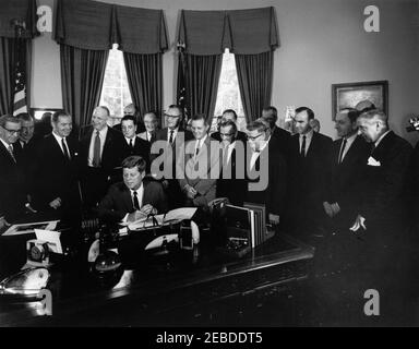 Bill signing - S. 2965 Public Law 87658, Accelerated Public Works Program, 9:30AM. President John F. Kennedy (seated at desk) signs S. 2965, the Public Works Acceleration Act. Looking on (L-R): Senator Dennis Chu00e1vez (New Mexico); Senator Jennings Randolph (West Virginia); Representative Edmond u201cEdu201d Edmondson (Oklahoma); Senator Robert S. Kerr (Oklahoma); Representative Alvin E. Ou2019Konski (Wisconsin); Administrator of the Area Redevelopment Administration, William L. Batt, Jr. (in back, partially hidden); Senator Hubert H. Humphrey and Representative John A. Blatnik, both of Stock Photo