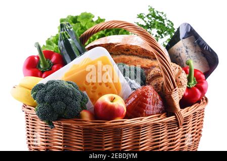Wicker basket with assorted grocery products isolated on white background Stock Photo