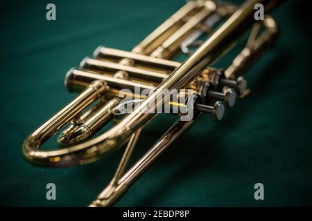 Close up macro still life of brass trumpet on green background Stock Photo