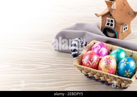 Five easter eggs trendy colored deep blue, green, orange, magenta and golden decorated in basket on white background. Copy space for text. Stock Photo