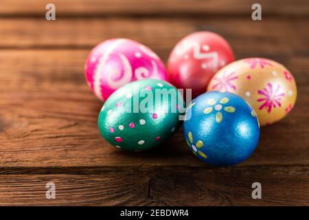 Five easter eggs trendy colored classic blue, green, orange, magenta and golden decorated on old wooden table. Copy Space. Stock Photo