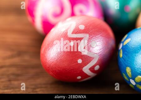 Five easter eggs trendy colored classic blue, green, orange, magenta and golden decorated on old wooden table. Copy Space. Stock Photo