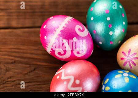 Five easter eggs trendy colored classic blue, green, orange, magenta and golden decorated on old wooden table. Copy Space. Stock Photo