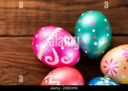 Five easter eggs trendy colored classic blue, green, orange, magenta and golden decorated on old wooden table. Copy Space. Stock Photo