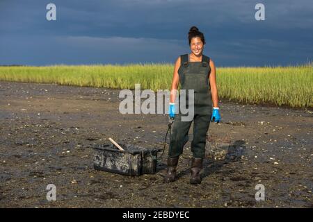 Portrait of asian female oyster picker in waders smiling at camera Stock Photo
