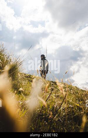 Young man looking the sunset in the mountains with yellow plants Stock Photo