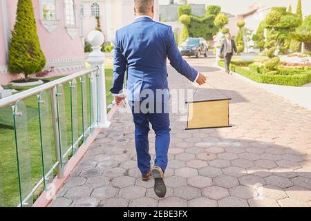 groom walking and holding a blackboard in his hand Stock Photo