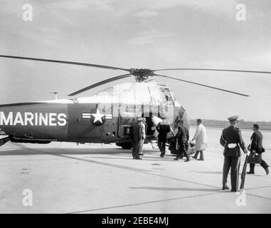 President Kennedy arrives at Andrews Air Force Base upon his return from Hyannis Port, 10:07AM. First Lady Jacqueline Kennedy climbs into a helicopter at Andrews Air Force Base, Maryland. Following Mrs. Kennedy are President John F. Kennedy; Secret Service Agent Gerald u0022Jerryu0022 Behn; White House Press Secretary Pierre Salinger; unidentified individuals. Stock Photo