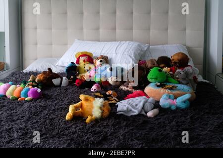 Stuffed toys messy on parent's bed Stock Photo