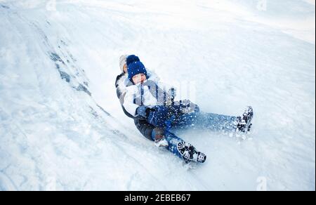 Mother and child tobogganing on a sledge Stock Photo