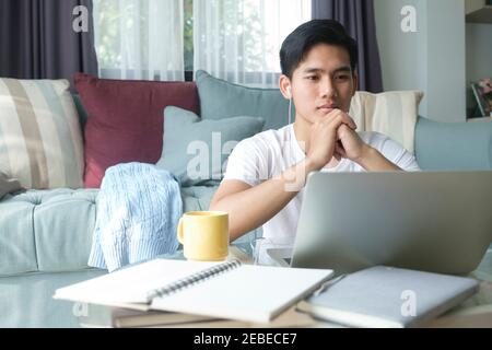 Young man working and learning online at home. Young man video call conference online with his colleagues. Stock Photo