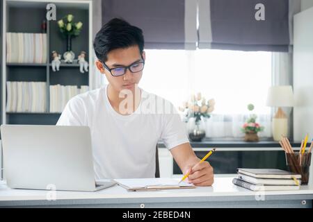 Young man working and learning online at home. Young man video call conference online with his colleagues. Stock Photo