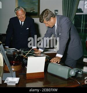 Presentation to President Kennedy of a John Adams letter to President Madison, 12:55PM. President John F. Kennedy leans over his desk to view an original letter written by former President John Adams to President James Madison, presented to President Kennedy by Alphonsus J. Donahue, Jr. (left). Oval Office, White House, Washington, D.C. Stock Photo