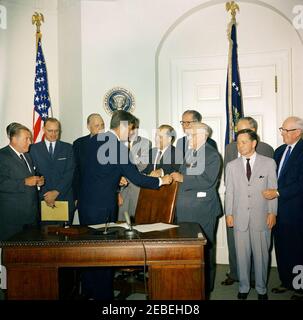 Bill signing u2013 HR 6874 Public Law 8798, NASA (National Aeronautics and Space Administration) Authorizations for Fiscal Year 1962, 12:00PM. President John F. Kennedy signs HR 6874, National Aeronautics and Space Administration (NASA) authorizations for fiscal year 1962. (L u2013 R): Senator Warren G. Magnusson (Washington); unidentified man (hidden by Senator Magnuson); Congressman Joseph E. Karth (Minnesota); Senator Robert S. Kerr (Oklahoma); President Kennedy; Congressman Overton Brooks (Louisiana, partially hidden); Congressman Vincent L. Anfuso (New York); Senator Clinton P. Anderson Stock Photo