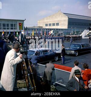 Arrival ceremony for Sylvanus Olympio, President of Togo, 11:00AM. President John F. Kennedy and President Sylvanus Olympio of Togo sit in bubbletop limousine at left, following arrival ceremonies for President Olympio. White House Secret Service agents Gerald A. u201cJerryu201d Behn, Roy Kellerman, and Bob Lilley stand behind car. Military Air Transport Service (MATS) Terminal, Washington National Airport, Washington, D.C. Stock Photo