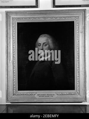 White House paintings: u0022Benjamin Franklin,u0022 by Benjamin Wilson (1759). Portrait painting of author and statesman Benjamin Franklin by Benjamin Wilson, 1759. Bottoms of two other paintings visible, with u201cCharles Brooking (1723-1759)u201d showing and small plaques on the frames engraved with inscription: u201cGiven in memory of Lieut. Joseph P. Kennedy, Jr. USNR.u201d White House, Washington, D.C. Stock Photo