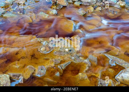 Close up of orange red river with iron ore and copper ore deposits in the Rio Tinto mining area Stock Photo