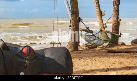 Africa beach with a hammock and a hanging swing in the background in the tropical part of Ghana Axim beach located in west africa Stock Photo