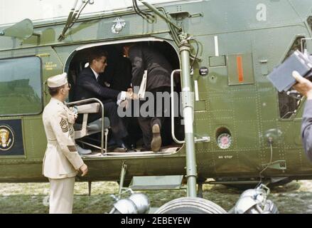 Commencement Address at the US Naval Academy, Annapolis, Maryland, 11:04AM. President John F. Kennedy (wearing sunglasses) sits inside a helicopter on the South Lawn of the White House en route to the commencement ceremony at the United States Naval Academy in Annapolis, Maryland. Stock Photo