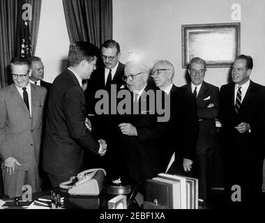 Bill signing u2013 HR 6518 Public Law 87-41, Inter-American Social and Economic Cooperation Program and the Chilean Reconstruction and Rehabilitation Program Act, 9:50AM. President John F. Kennedy shakes hands with former President Harry S. Truman after signing Public Law 87-41, Inter-American Social and Economic Cooperation Program and the Chilean Reconstruction and Rehabilitation Program Act. Others, L-R: Congressman Otto Passman (Louisiana); Congressman Gerald R. Ford, Jr. (Michigan); unidentified; Senator George D. Aiken (Vermont); unidentified; Senator Thomas H. Kuchel (California). Oval Stock Photo
