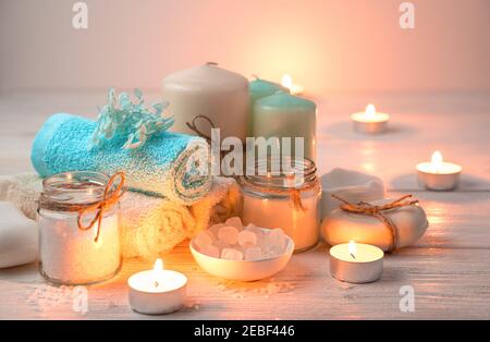 Candles, towels, soap and salt on the background of burning candles. Stock Photo