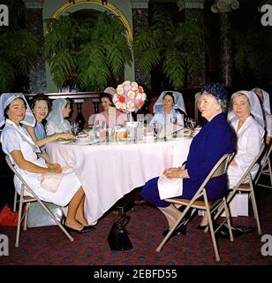 First Lady Jacqueline Kennedy (JBK) attends the Senate Ladies Red Cross Unit Luncheon. First Lady Jacqueline Kennedy attends a luncheon for members of the Senate Ladies Red Cross Unit in the Old Supreme Court Chamber, United States Capitol Building, Washington, D.C. The Red Cross unit (also known as u201cLadies of the Senateu201d) is comprised of the wives of members of the US Senate. Left to right: Noel Clark (wife of Senator Joseph S. Clark of Pennsylvania); Senator Maurine Neuberger (Oregon); unidentified; Mrs. Kennedy; Lady Bird Johnson; Senator Margaret Chase Smith of Maine (mostly hidd Stock Photo