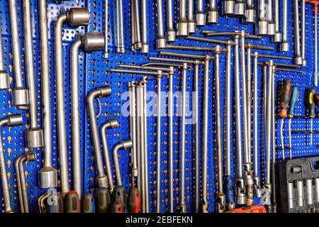 A range of used mechanic tools, from combination wrenches to screwdrivers and socket wrench. All hanging on blue panels. Perfect shot for arts and cra Stock Photo