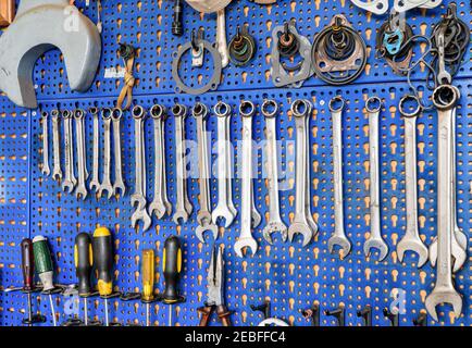 Set of screwdrivers and wrenches hanging on wall with assorted auto  mechanic tools in garage Stock Photo - Alamy