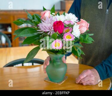 A bouquet of mixed flowers in a glass vase. Stock Photo