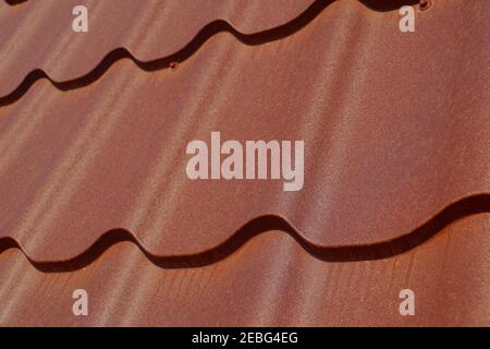 A frequently used method of covering the roof. A fragment of a roof made of steel tiles. Stock Photo