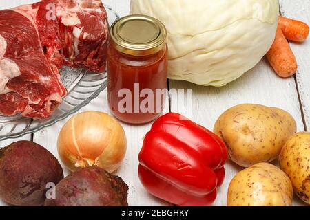 A set of products for making a delicious soup known as Ukrainian borsch. Beef brisket, white cabbage, potatoes, beets, carrots, bell peppers and tomat Stock Photo